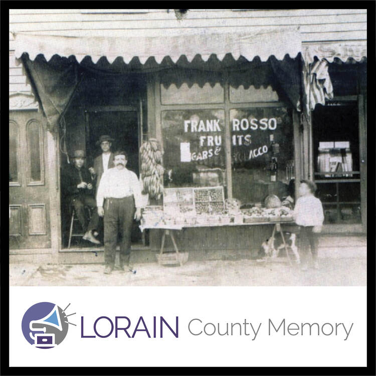 black and white photo of Frank Rosso's Fruit store with four men, a dog and boy standing outside